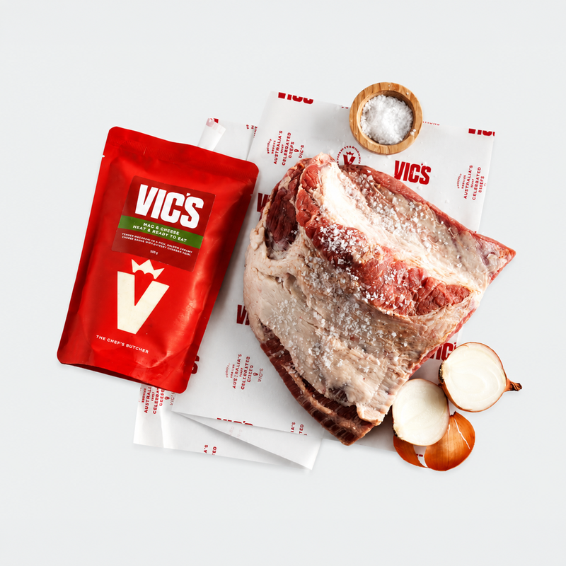 Raw meat with Vics seasoning packets and ingredients on a white background