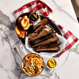 Platter of barbecue brisket with sides on a marble surface
