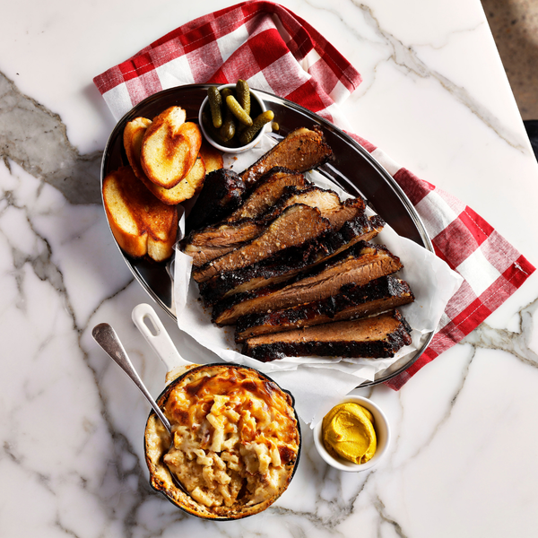 Platter of barbecue brisket with sides on a marble surface