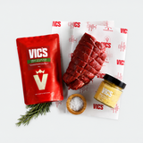 Vics branded packaging with raw meat, salt, and a jar on a branded paper background